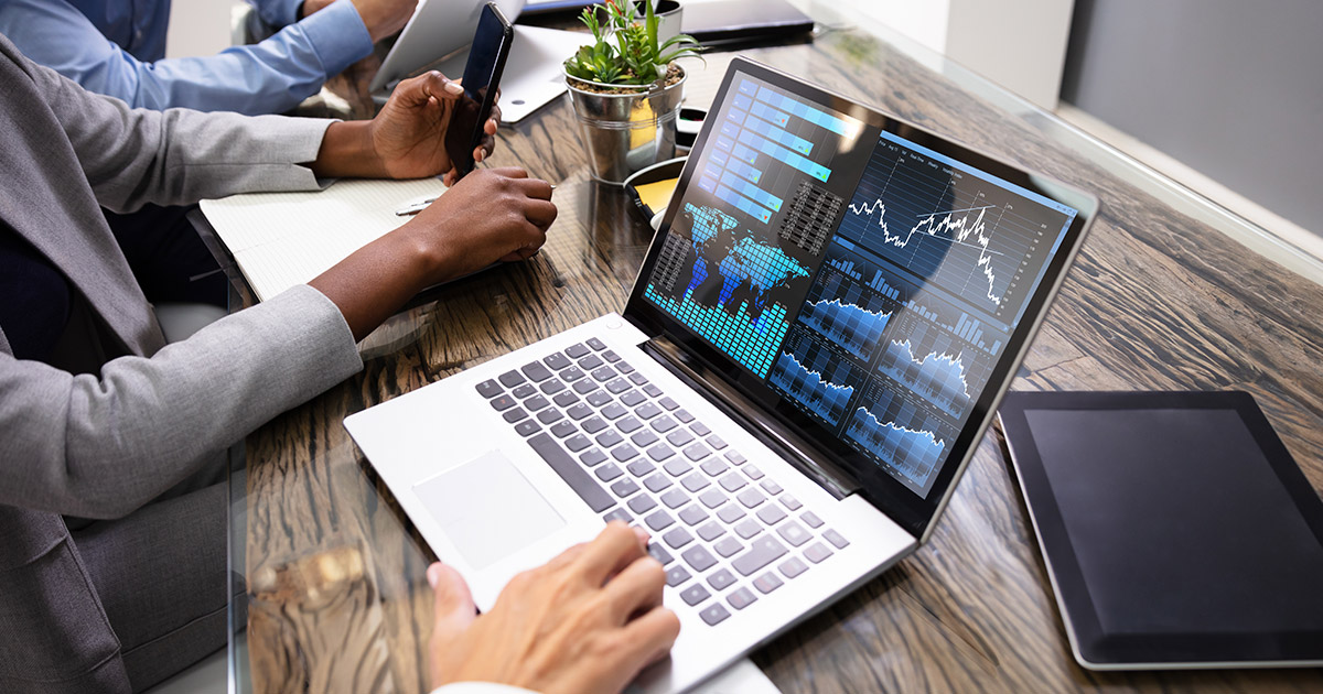 Group Of Businesspeople Examining Graph On Computer