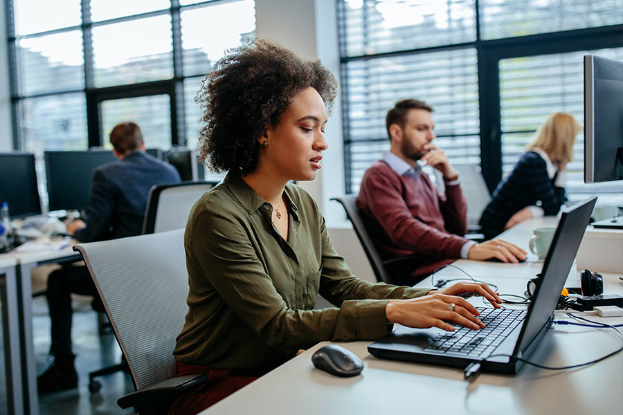 Woman in office focused on laptop