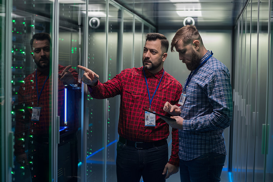 Two men inspecting server room