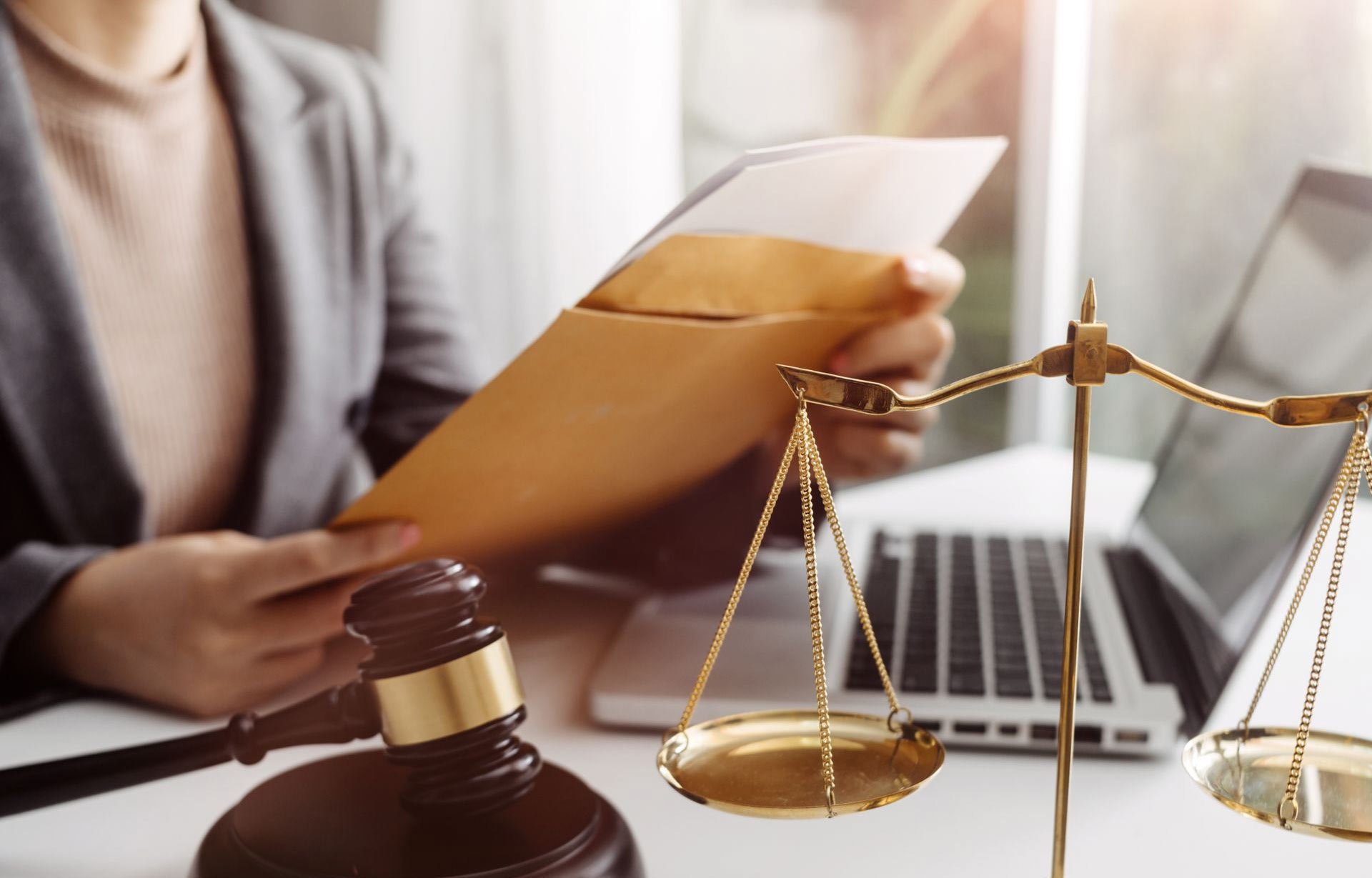 lawyer looking at documents with gavel and laptop on desk