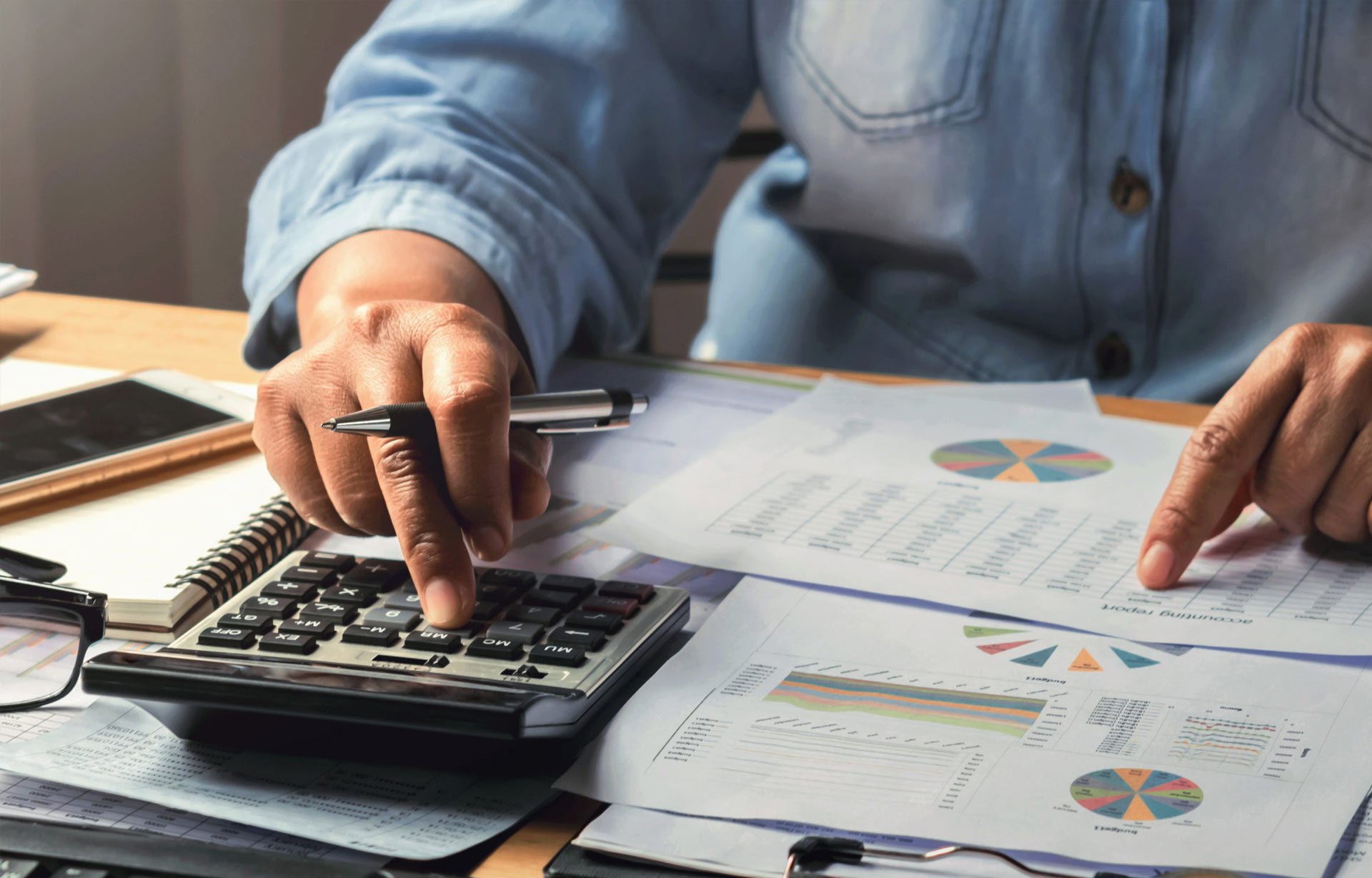 man doing accounting work using calculator