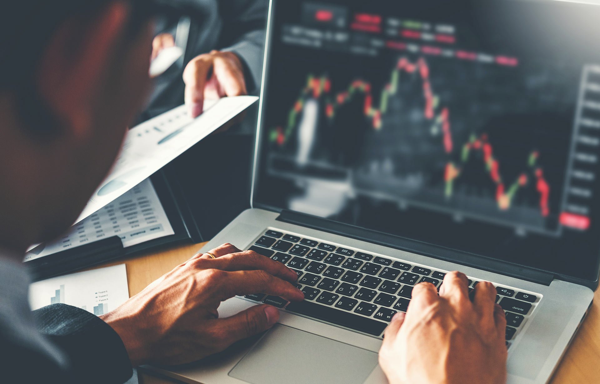 man looking at stock charts on laptop