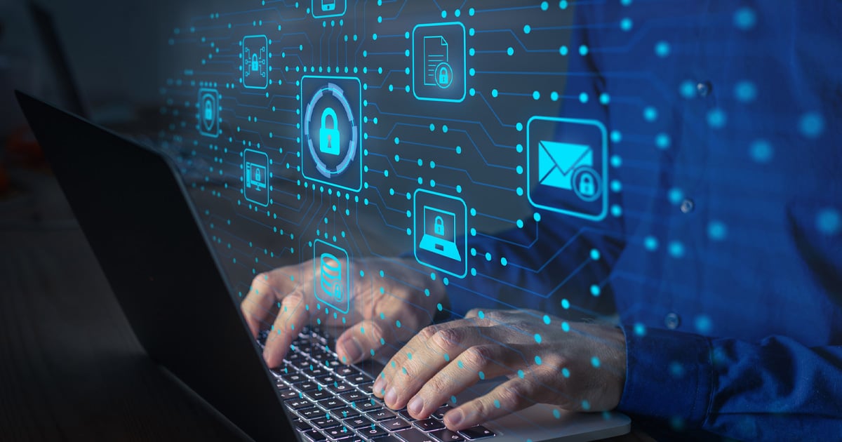 Cyber security IT engineer typing on a keyboard with secure data icons overlay to display secured regions of the computer 