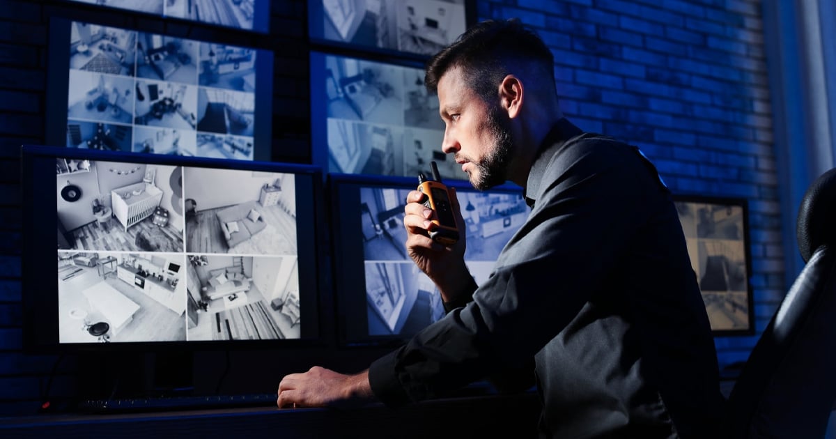 security guard reviewing footage of various cameras on multiple computer screens